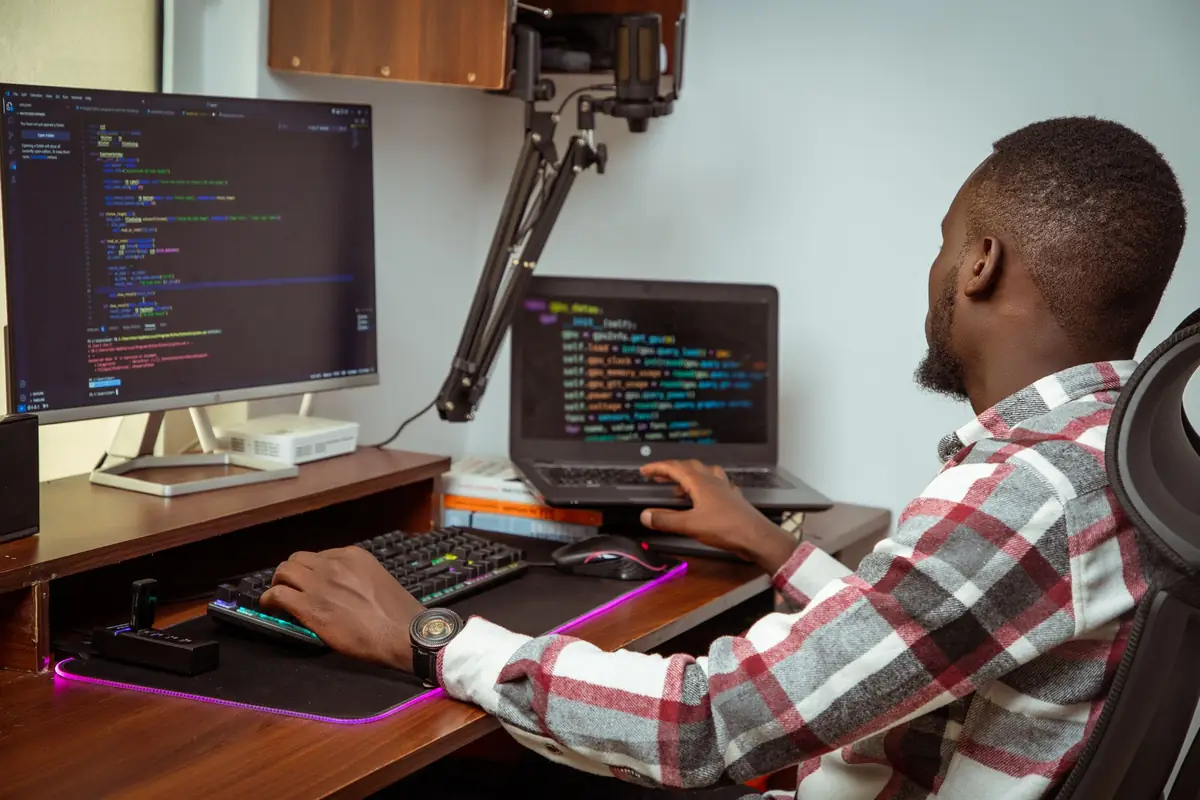 Developer at work in front of code on two screens
