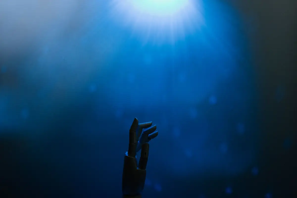 A robotic hand reaching toward a blue light